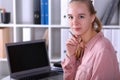 Young office employee sits at desk in front laptop