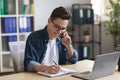 Young Office Manager Talking On Mobile Phone And Taking Notes To Notepad Royalty Free Stock Photo