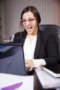 Young office worker girl dressed in a suit sitting at desktop