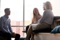 Office workers listening to old woman mentor talking at meeting