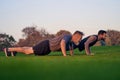 The young and old men push up together on the grass. Royalty Free Stock Photo