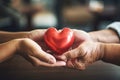 Young and old people hands holding red heart together. Love, help, social responsibility, donation, charity, ecology Royalty Free Stock Photo