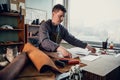 A young old-school shoemaker fulfills an order to make an exclusive leather product. Portrait in the studio