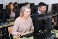 Young and older businesswomen and businessmen in open plan office