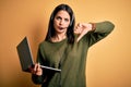 Young operator woman with blue eyes working on call center using computer laptop and headset with angry face, negative sign Royalty Free Stock Photo