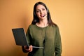 Young operator woman with blue eyes working on call center using computer laptop and headset with a happy face standing and Royalty Free Stock Photo