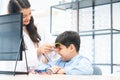 Young optometrist woman or doctor helping Indian cute child boy have fun trying and choosing a new eyeglasses frame at Royalty Free Stock Photo