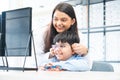 Young optometrist woman or doctor helping Indian cute child boy have fun trying and choosing a new eyeglasses frame at Royalty Free Stock Photo