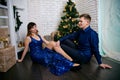 Young ordinary family of two. Young husband and wife near christmas tree. Happy young hetero couple decorate christmas tree at