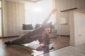 Young ordinary man go in for sport at home. Persistant freshman workout beginner stand in side plank position and look