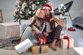 A young ornate couple sitting on the floor at home surrounded by Xmas presents. Christmas, relationship, love, together Royalty Free Stock Photo