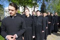 Young Orthodox monks waiting for sign to go during walk in a monastery garden. Kyiv, Ukraine