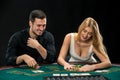 Young ÃÂouple playing poker, woman taking poker chips after winning