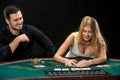 Young ÃÂouple playing poker, woman taking poker chips after winning