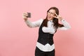 Young overjoyed business woman in glasses doing taking selfie shot on mobile phone showing victory sign on pink Royalty Free Stock Photo