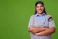 Young overweight beautiful Indian businesswoman against green background
