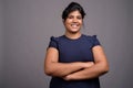 Young overweight beautiful Indian woman against gray background Royalty Free Stock Photo