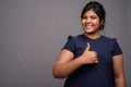 Young overweight beautiful Indian woman against gray background Royalty Free Stock Photo