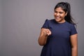 Young overweight beautiful Indian woman against gray background Royalty Free Stock Photo