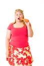 Young overweight blond woman eating raw carrot