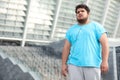 Young overweight man wearing earphones training