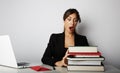 Young overwhelmed girl working hard. Young woman student shock of many books.Female model front of huge pile of books.