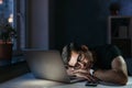 Overworked man sleeping on laptop at night