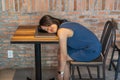 Young overworked millennial fall asleep on laptop at wooden table