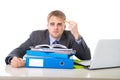 Young overworked and overwhelmed businessman in stress leaning on office folder exhausted and depressed