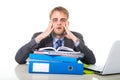 Young overworked and overwhelmed businessman in stress leaning on office folder exhausted and depressed