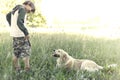 Young owner teaches his dog the game of stick