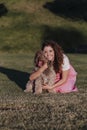 Young owner woman with her brown spanish water dog having fun outdoors in a park at sunset. love for animals concept