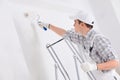 Young painter painting a white wall Royalty Free Stock Photo