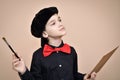 Young painter with red bow tie and black shirt and cap holding paint brush and art palette Royalty Free Stock Photo