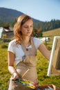 Young painter at work in the mountains