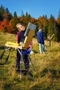 Young painters at work near waterfall Royalty Free Stock Photo