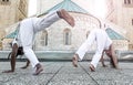 Young pair capoeira partners performing kicks outdoor