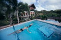 A pair of lovers swims in the pool on a tropical island. Newlyweds relaxing in the water in the outdoor pool