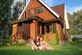 Young pair sitting near new house