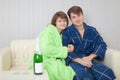 Young pair on a sofa with sparkling wine Royalty Free Stock Photo