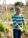 Pakistani man gardener working at land with garden mattock