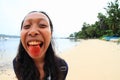 Young Papuan woman with tongue red from betel