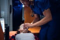 Young paramedic giving an oxygen mask to his female patient in an ambulance car Royalty Free Stock Photo