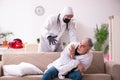Young paramedic visiting old man at home Royalty Free Stock Photo