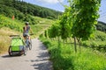 Young Parent Cycling With Bike Trailer