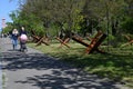 Young parents with a baby carriage walk past rows of czech hedgehogs in Kyoto Park on the outskirt of Kyiv