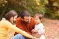 Young parents with baby girl in autumn park Royalty Free Stock Photo