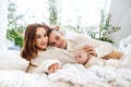 Happy family with baby having fun in the bedroom while they are lying on the bed on Christmas holidays. Royalty Free Stock Photo