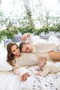 Happy family with baby having fun in the bedroom while they are lying on the bed on Christmas holidays. Royalty Free Stock Photo