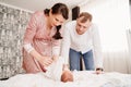 young parents change their newborn baby on a bed in the bedroom. Royalty Free Stock Photo